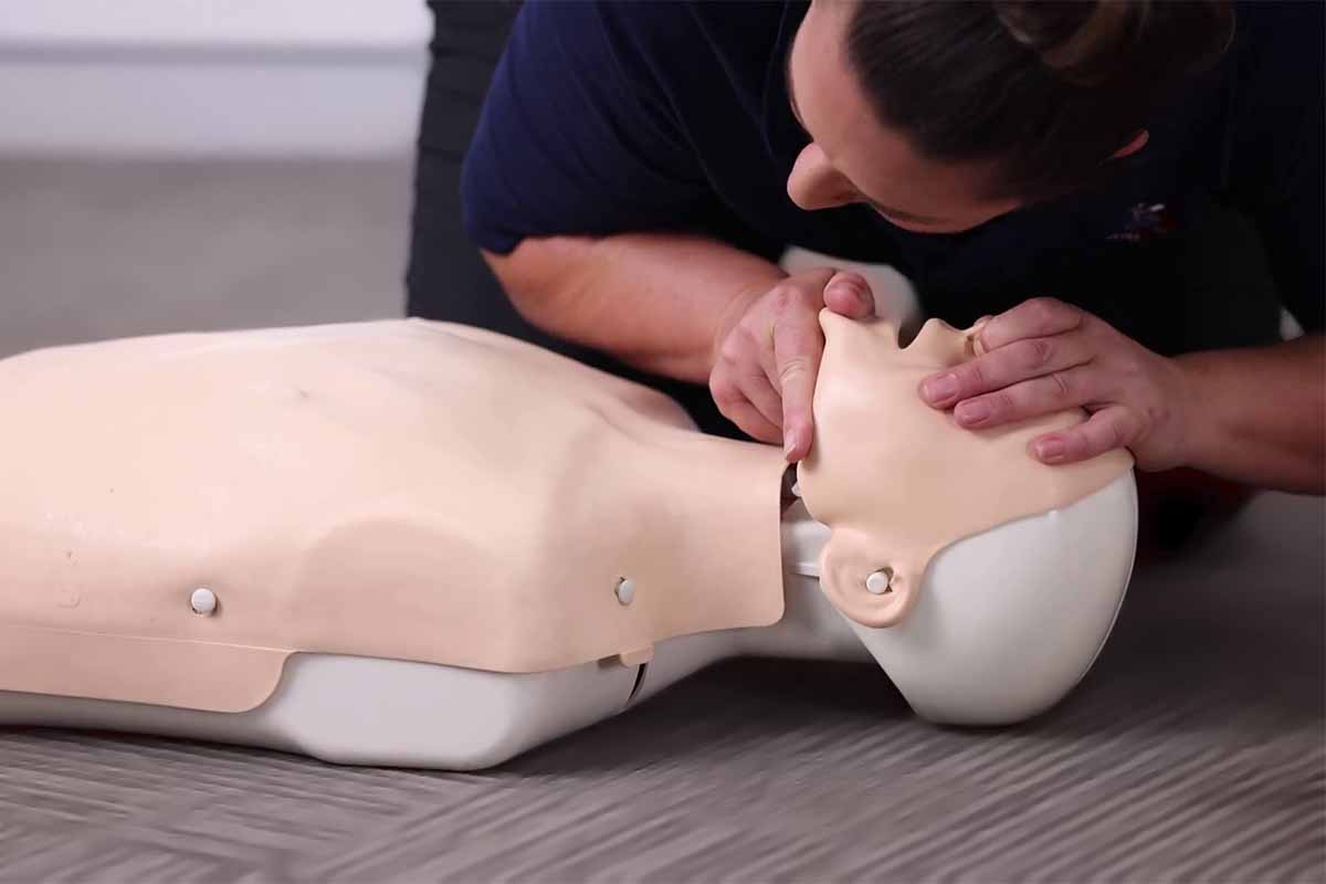 Person performing CPR on a Manikin during HLTAID009 Course