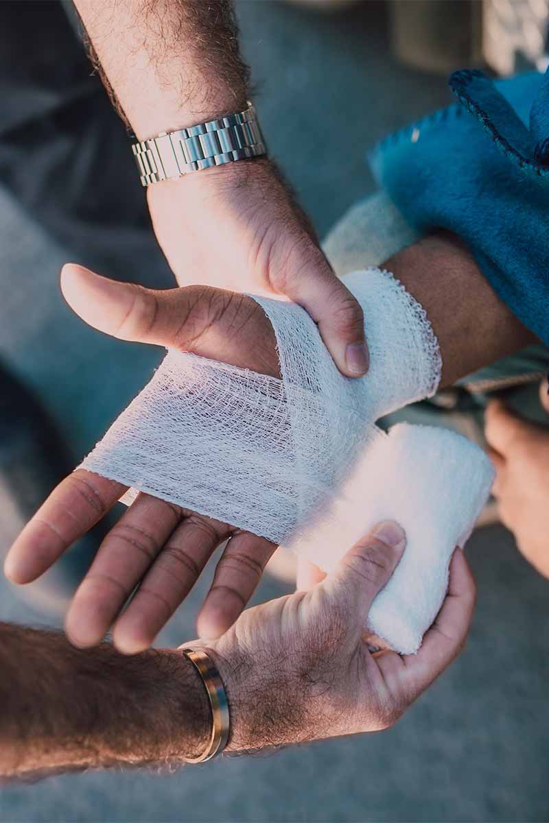 Person applying bandage to hand
